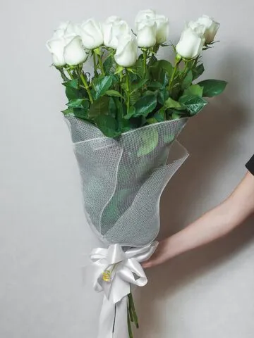 Bouquet of white meter-long roses in a net