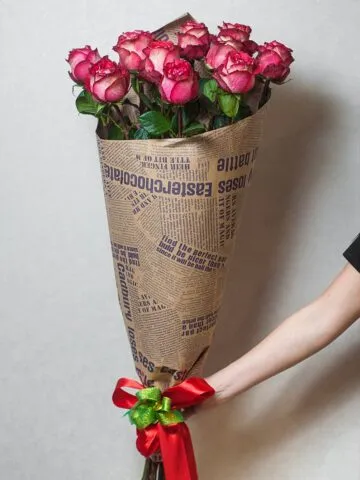 Bouquet of burgundy meter-long roses in kraft paper